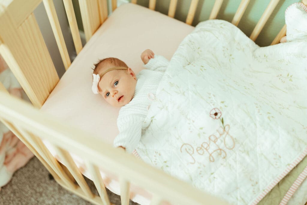 Scottsdale lifestyle newborn photography featuring sleepy newborn baby in floral nursery during in-home newborn session near Phoenix Arizona