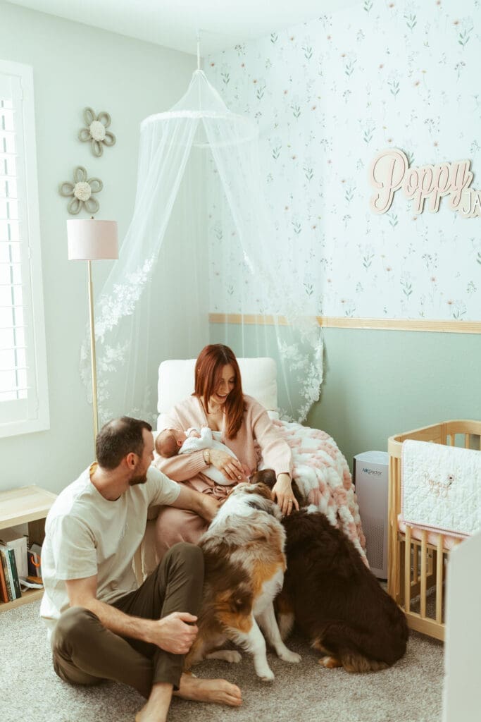 In-home newborn photography in Paradise Valley AZ with parents snuggling newborn baby girl in softly lit nursery