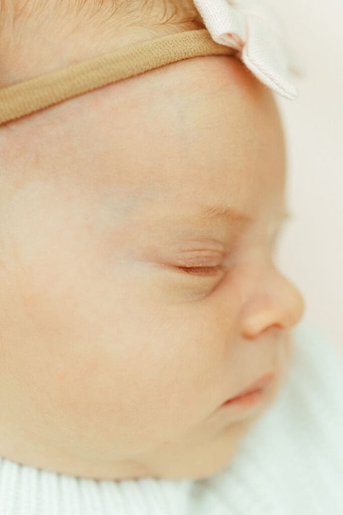 Newborn baby girl photographed in elegant blush and sage nursery during Paradise Valley in-home newborn session