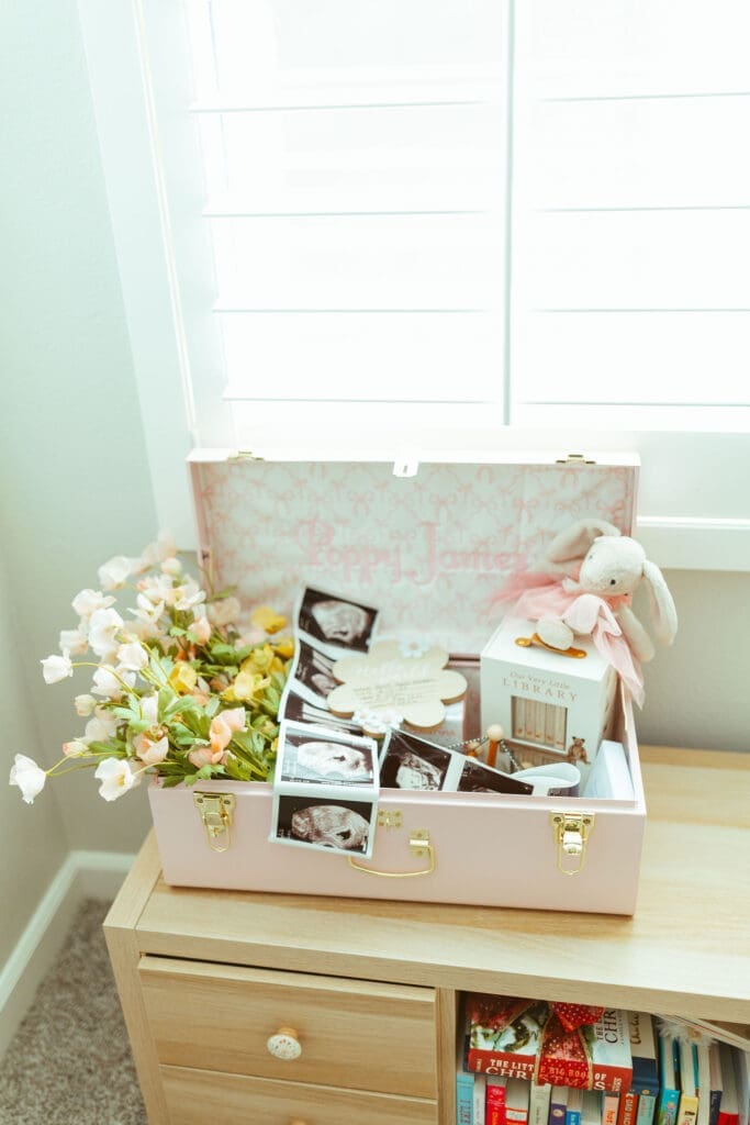 Scottsdale newborn photography session featuring parents cuddling newborn baby girl beside large nursery windows with natural light