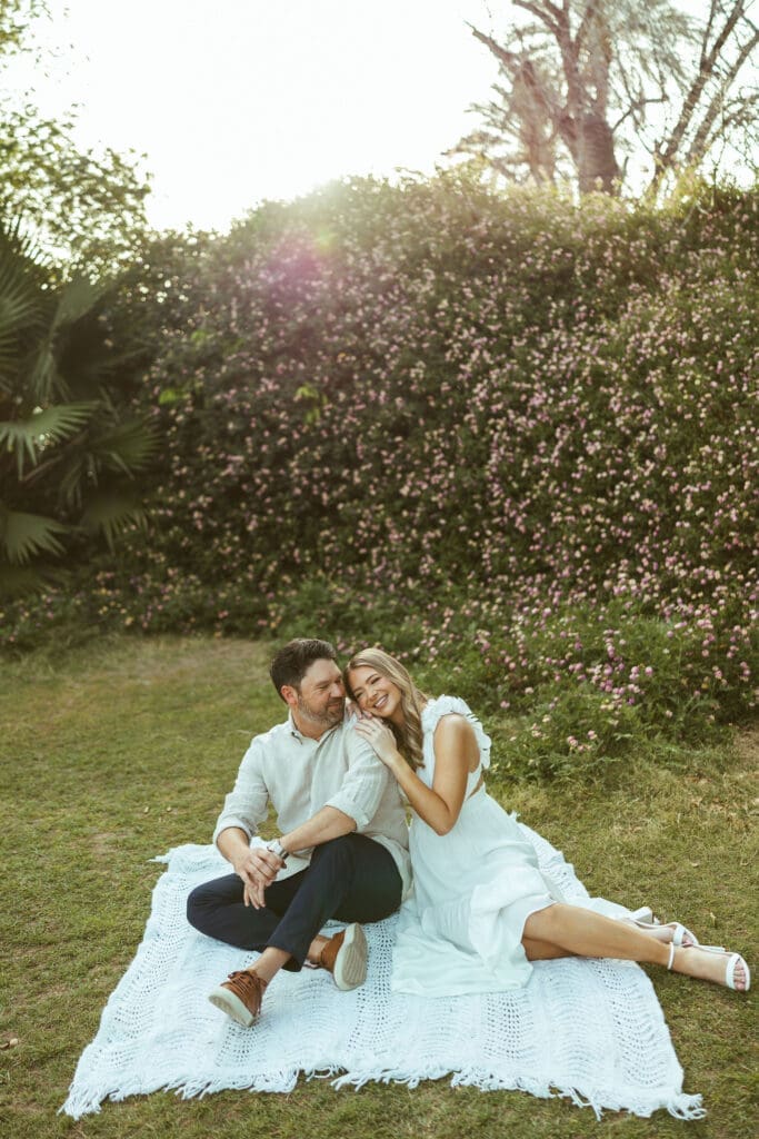 Mesa engagement photographer documenting candid engagement moments in lush green Arizona field near Gilbert and Chandler