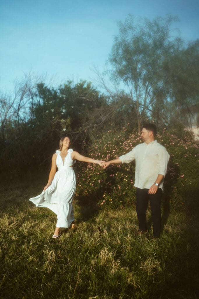 Mesa engagement photographer capturing intimate engagement session with greenery, open fields, and cinematic sunset lighting