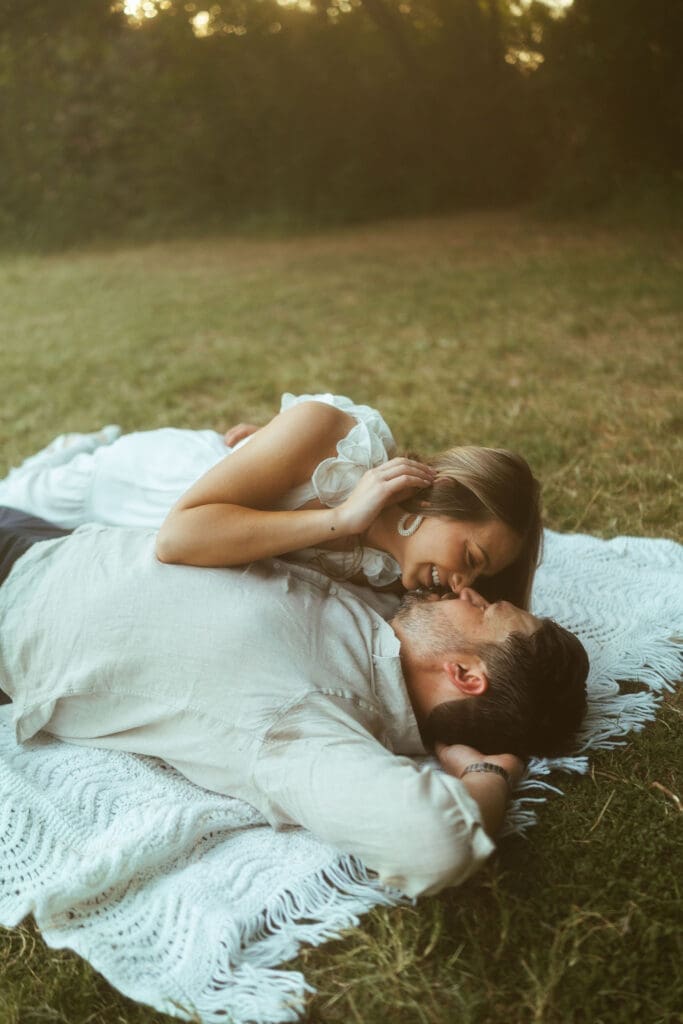 Romantic engagement session at The Meadow in Mesa Arizona featuring couple walking hand in hand through lush green field during golden hour