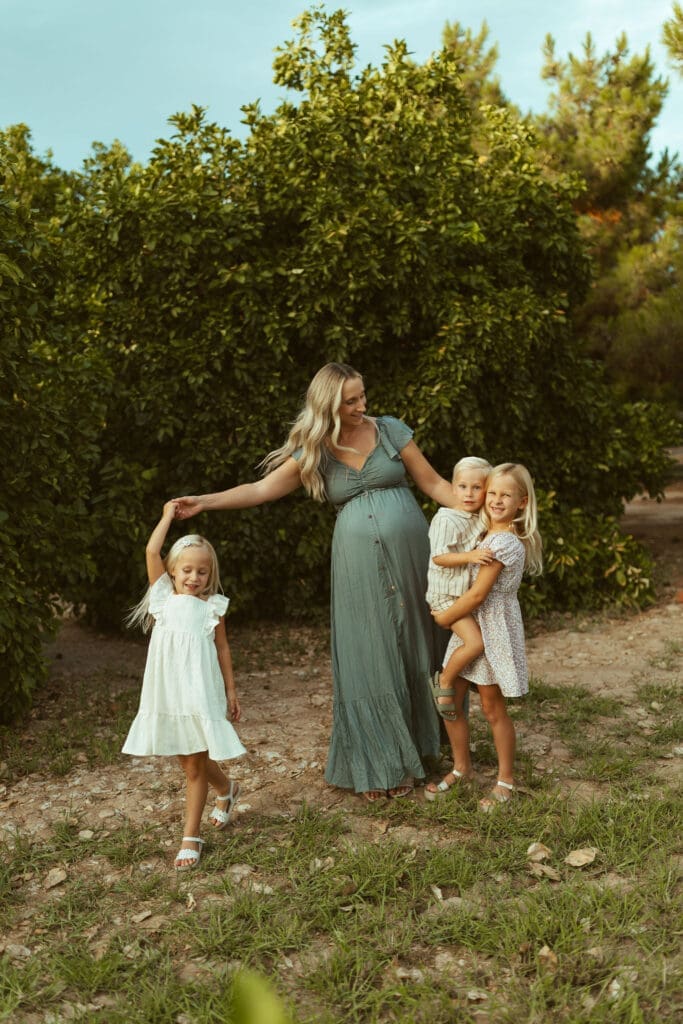 Arizona maternity photographer documenting joyful family connection during outdoor maternity session with young children
