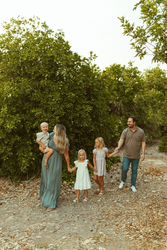 Arizona family maternity photographer documenting siblings celebrating new baby during outdoor maternity photos in Queen Creek