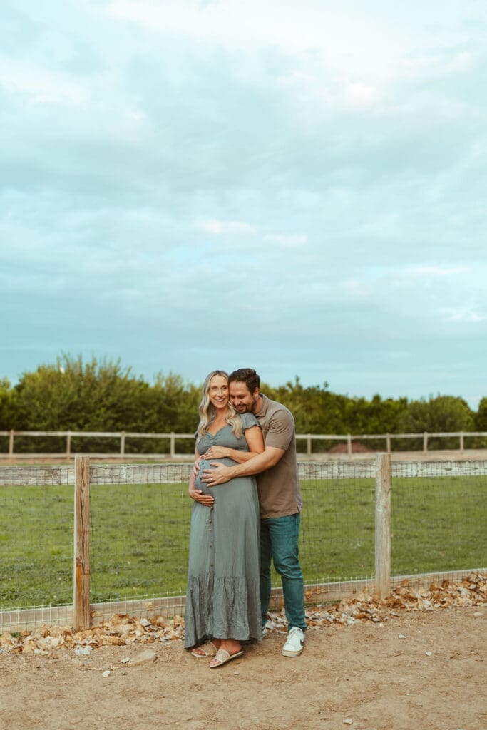 Arizona maternity photographer capturing romantic maternity portrait of expecting couple at Hagen Farms in Queen Creek