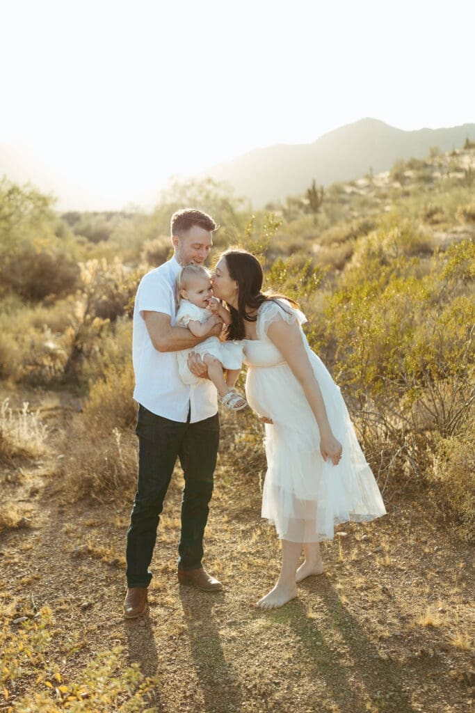 Mesa maternity photographer capturing expecting parents and toddler during golden hour desert maternity session at Phon D Sutton Recreation Area in Mesa Arizona