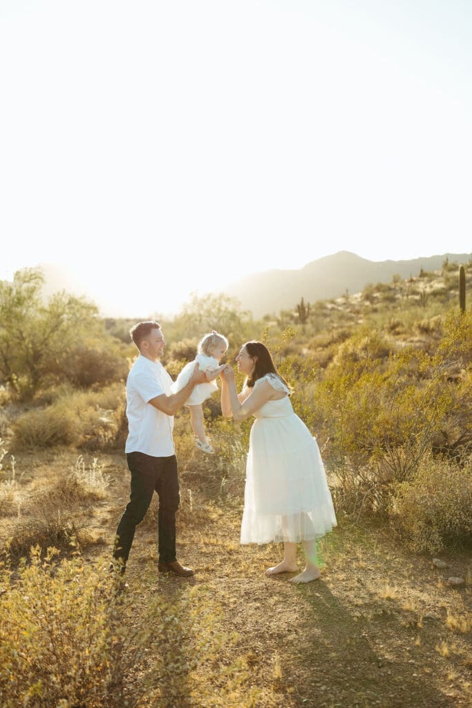Phoenix maternity photography featuring expecting family laughing together during sunset maternity session in Mesa Arizona