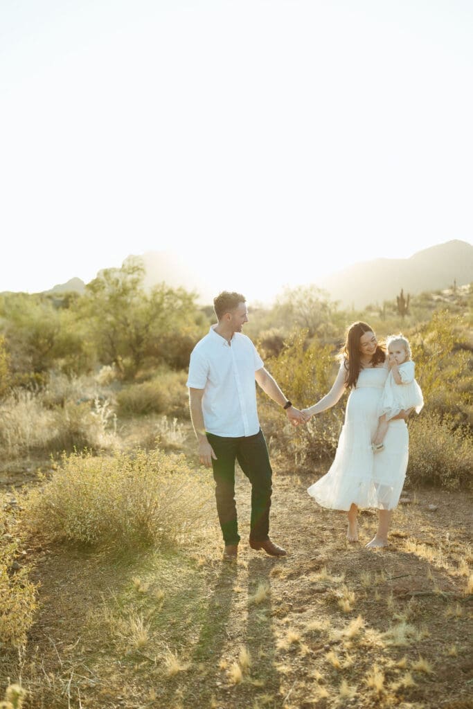 Phoenix Arizona maternity photography with toddler cuddling parents during luxury sunset maternity session