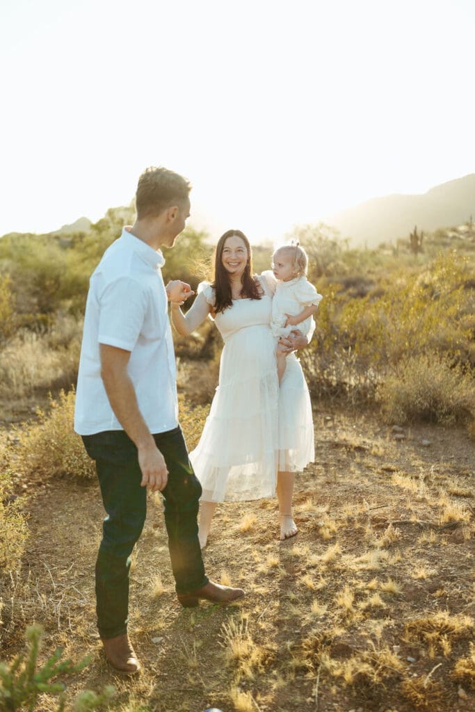 Paradise Valley maternity photography featuring joyful family walking together during sunset maternity session in Mesa Arizona