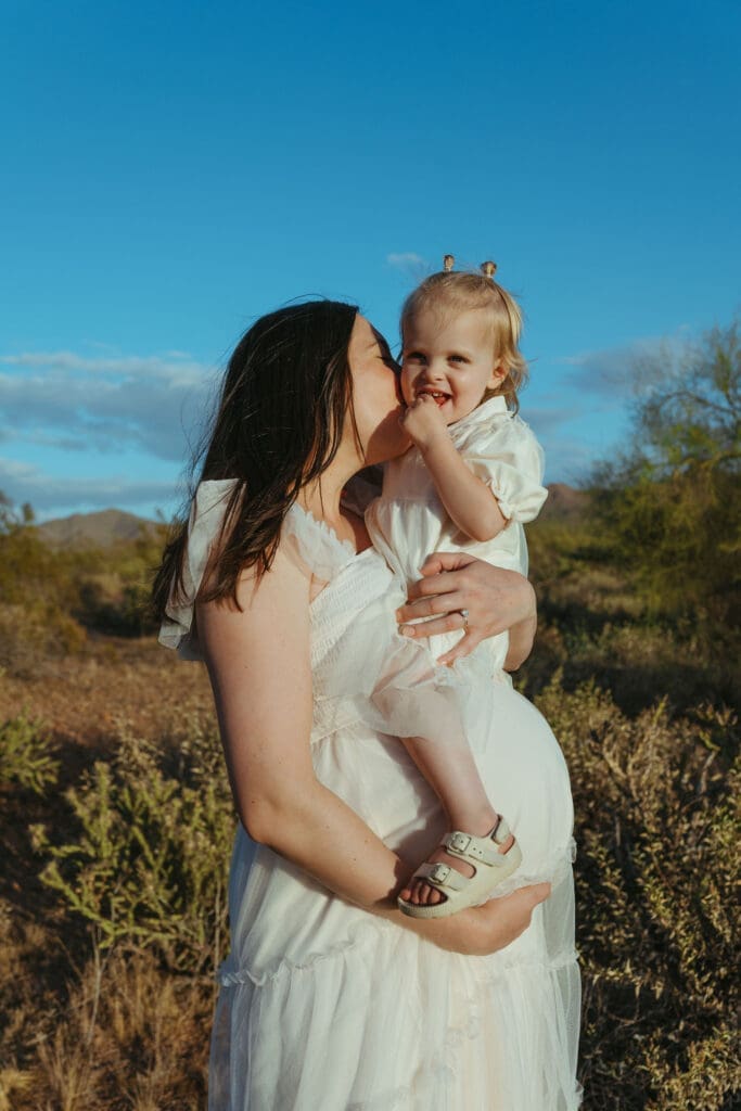Phoenix maternity photographer capturing mother holding toddler during golden hour desert family maternity session