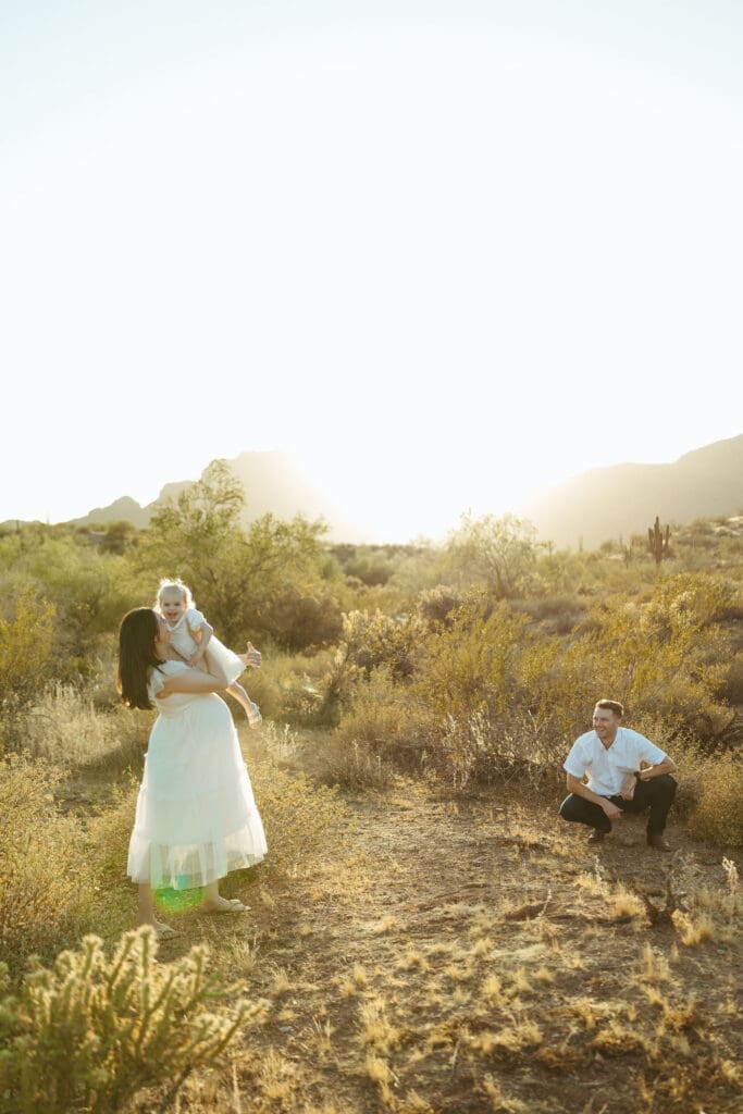 Scottsdale maternity photographer documenting emotional family maternity portraits with golden desert light and mountain views