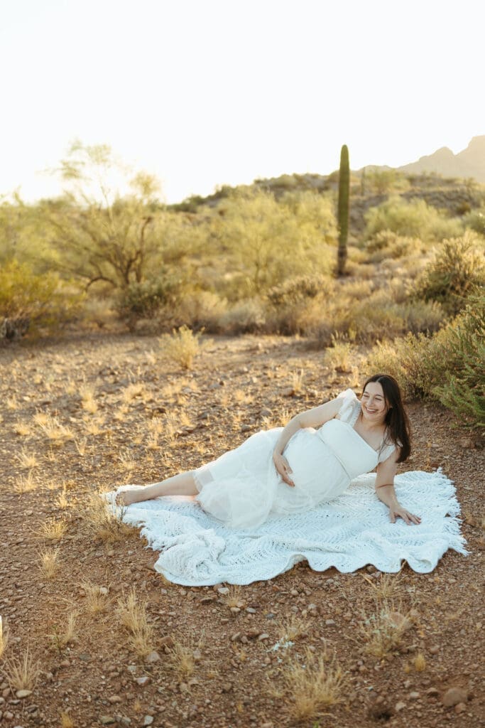 Paradise Valley maternity photography featuring expecting mother posing on blanket surrounded by Sonoran Desert scenery in Mesa Arizona