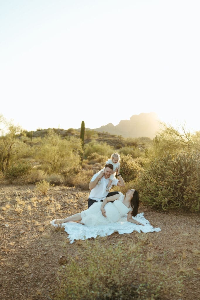 Scottsdale maternity photography featuring expecting mother in flowing white dress during luxury desert maternity session