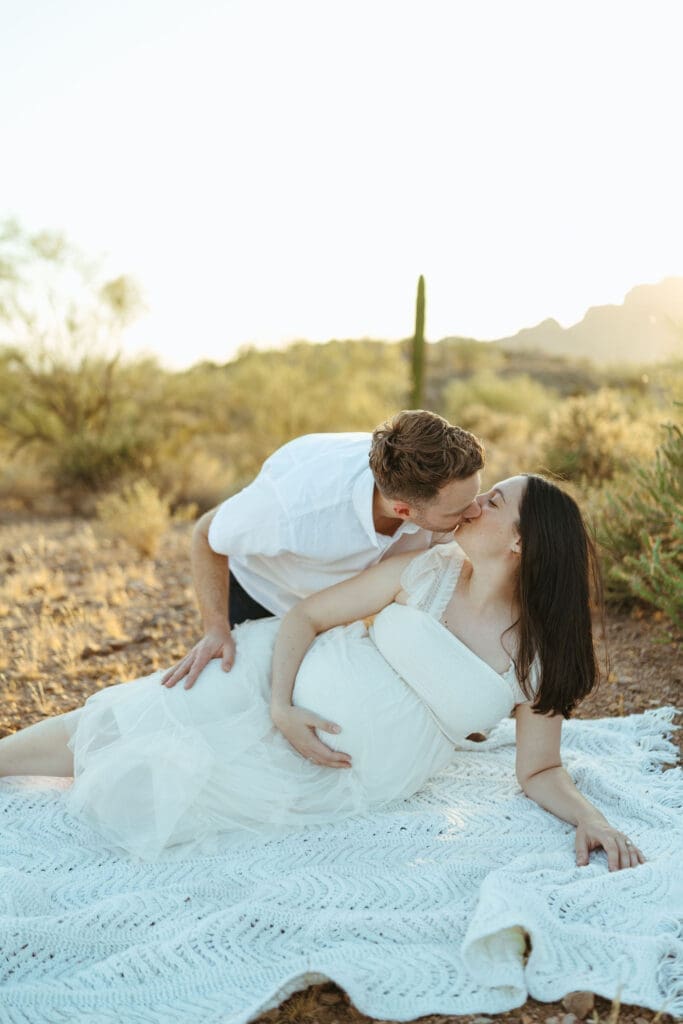 Arizona maternity photographer capturing romantic maternity portraits of expecting parents during golden hour desert session