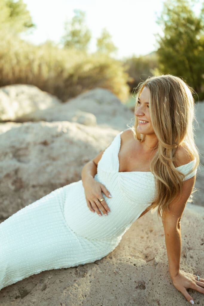Pregnant couple walking hand in hand along the Salt River during a golden hour maternity session in Mesa Arizona.