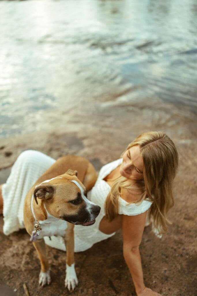 Overhead maternity photo of expecting mother and dog beside the Salt River during golden hour in Mesa Arizona.