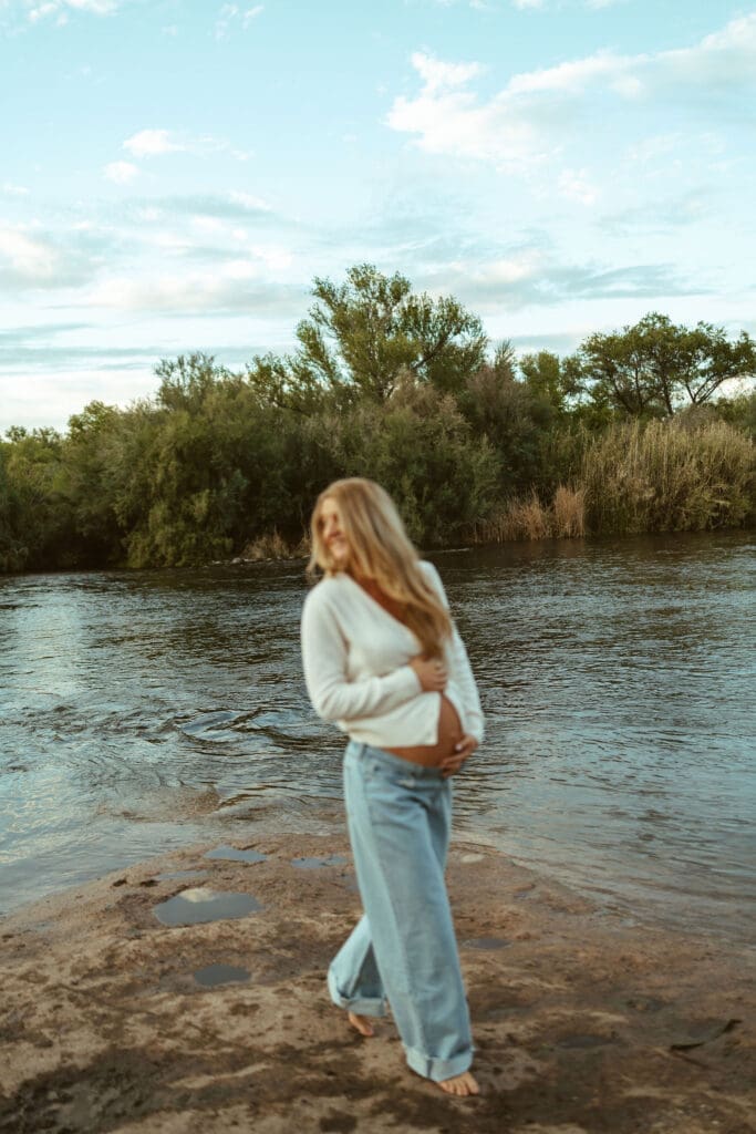 Artistic maternity portrait with soft motion blur beside the Salt River during sunset at Phon D Sutton Recreation Area.