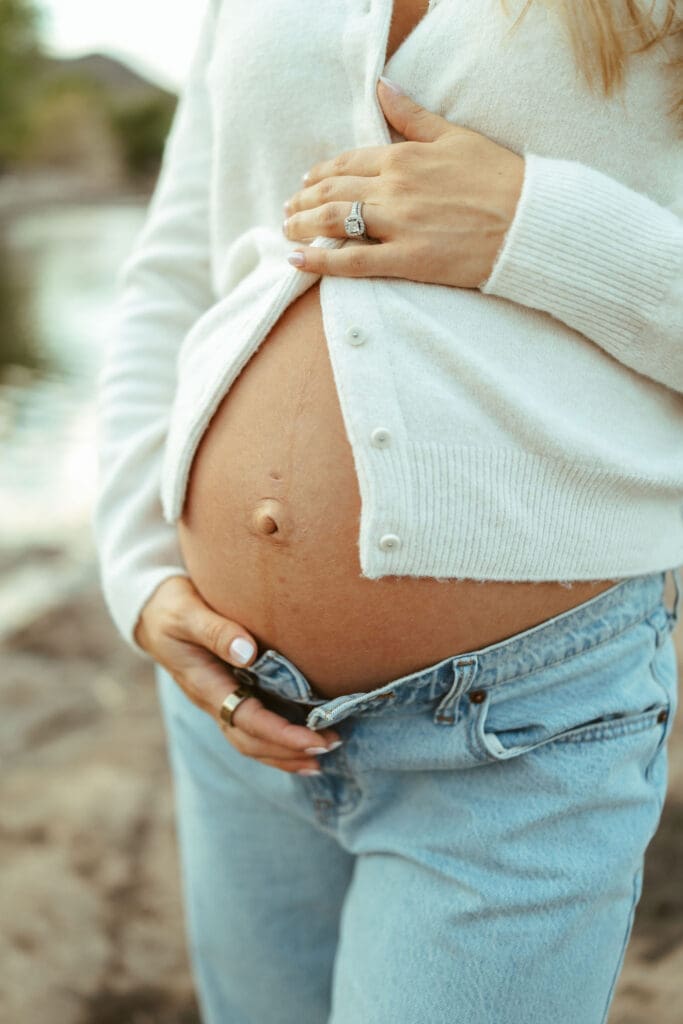 Close-up maternity detail photo showing baby bump and wedding ring during a Salt River maternity session in Arizona.