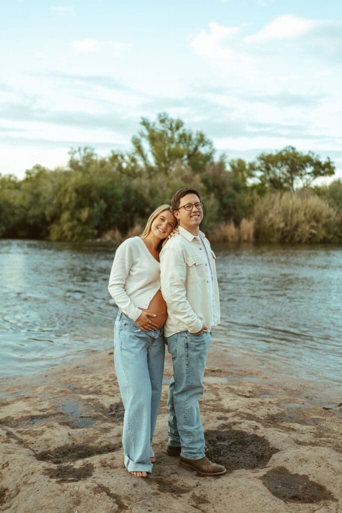 Couple embracing beside the Salt River during a dreamy maternity session near Phoenix Arizona.