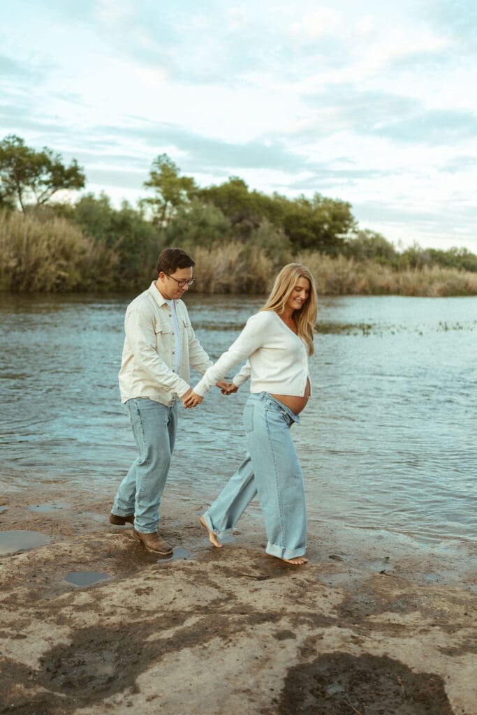 Expecting couple standing in the water during a maternity session in Mesa Arizona at golden hour.