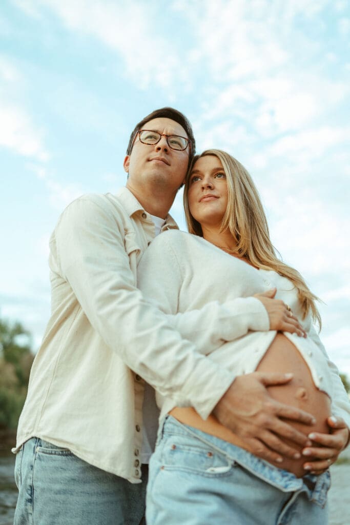 Romantic maternity session at the Salt River featuring casual neutral outfits and candid connection.