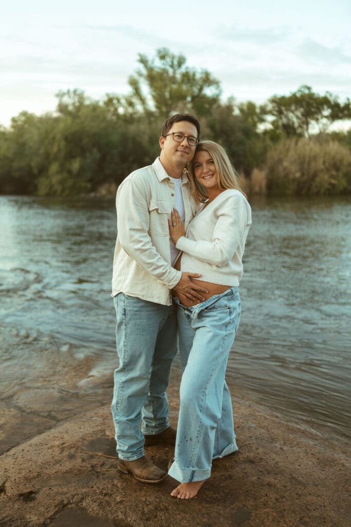Artistic maternity portrait of expecting mother standing in the river during sunset near Mesa Arizona.