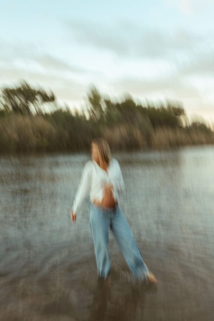 Outdoor maternity session with soft motion blur and glowing sunset light beside the Salt River.