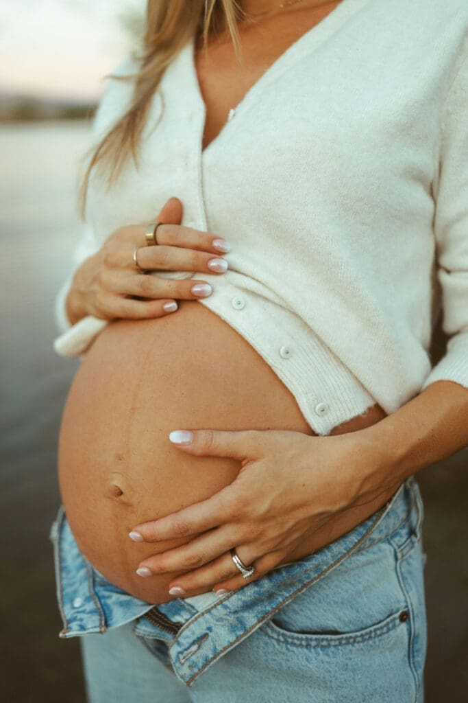 Close-up maternity photo showing baby bump detail and neutral casual styling during an Arizona maternity session.