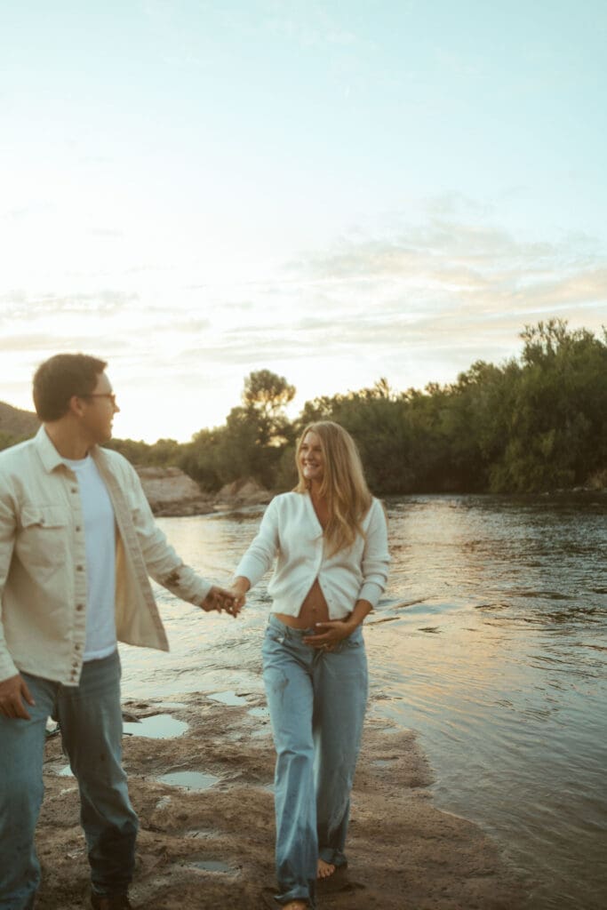 Romantic maternity session in Mesa Arizona featuring barefoot walking and sunset light beside the river.