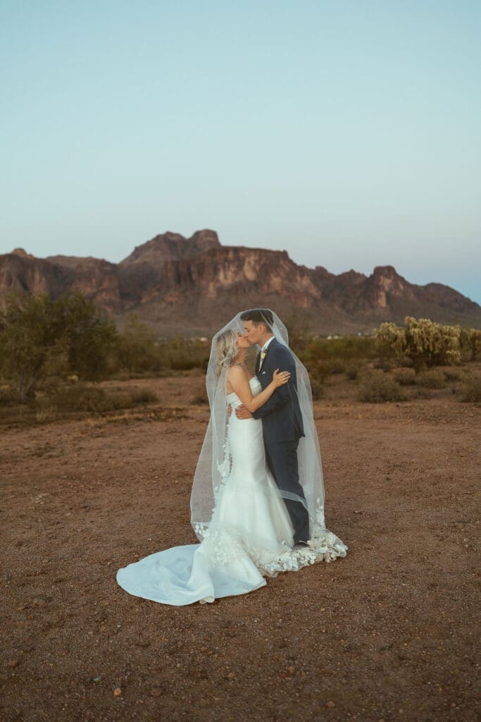 Bride and groom kissing in the desert during wedding day at The Paseo