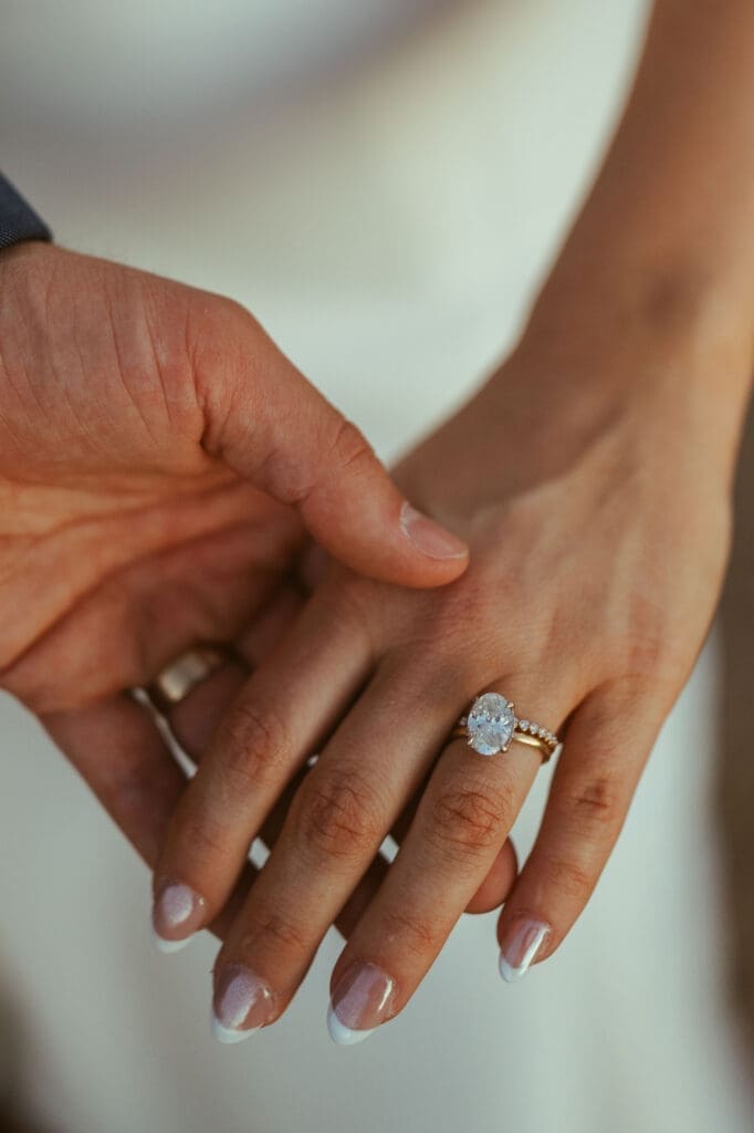 Bride and groom holding hands beneath desert mountains at The Paseo Arizona