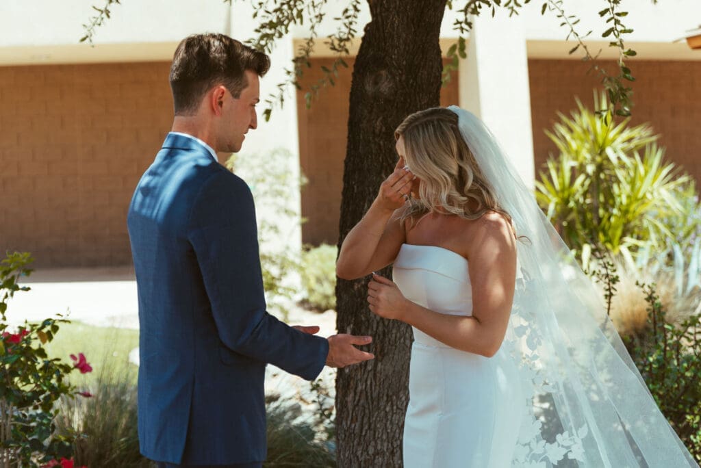 Bride tapping groom on shoulder during romantic first look in Arizona