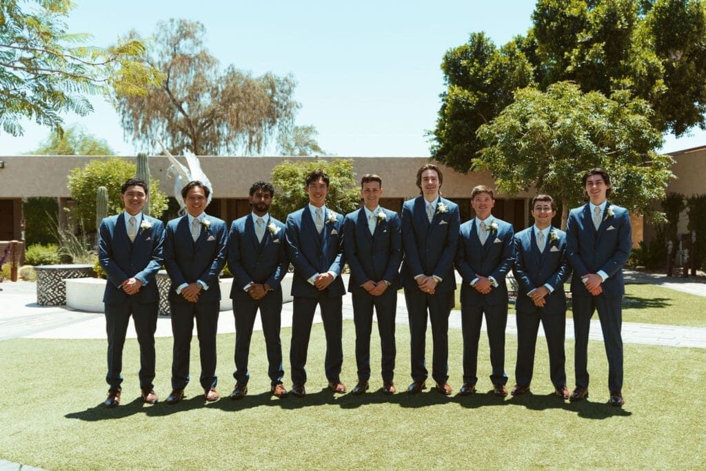 Groomsmen walking together in Arizona desert before wedding ceremony at The Paseo