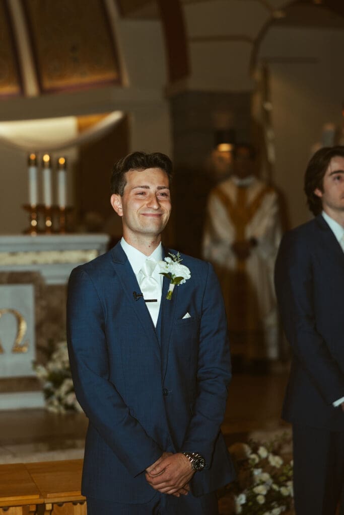 Groom watching bride walk down aisle at Scottsdale Catholic church wedding