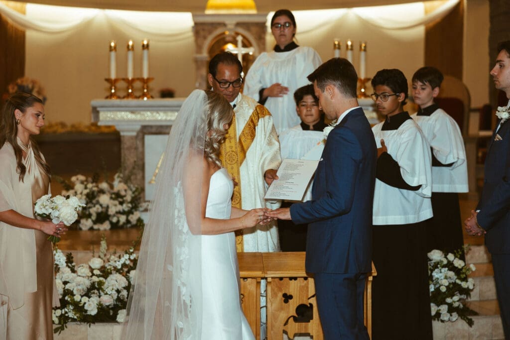 Bride and groom kneeling during Catholic wedding ceremony in Arizona church