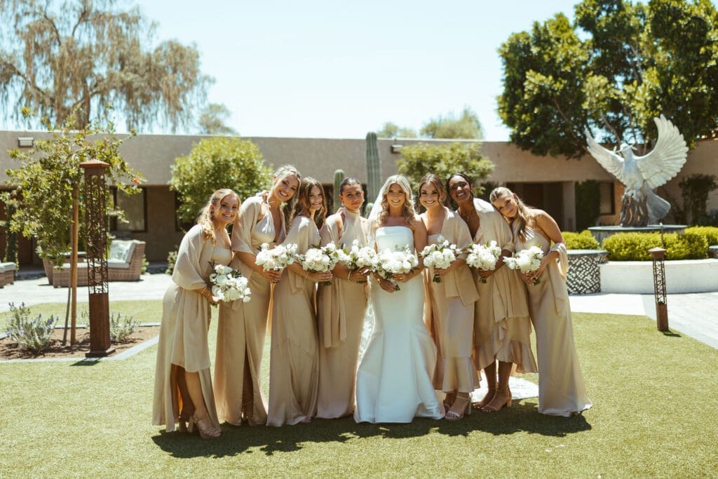 Bridesmaids posing together in champagne satin dresses during Arizona wedding day