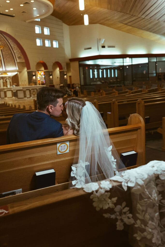 Bride and groom sharing first kiss during Catholic ceremony in Scottsdale Arizona