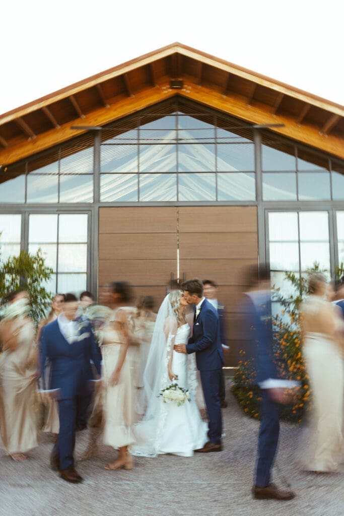Bride and groom posing with wedding party in Arizona desert at The Paseo
