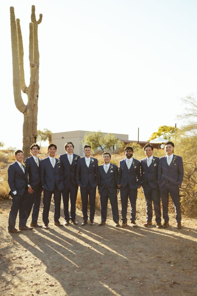 Groom posing with groomsmen in navy suits during Arizona wedding day