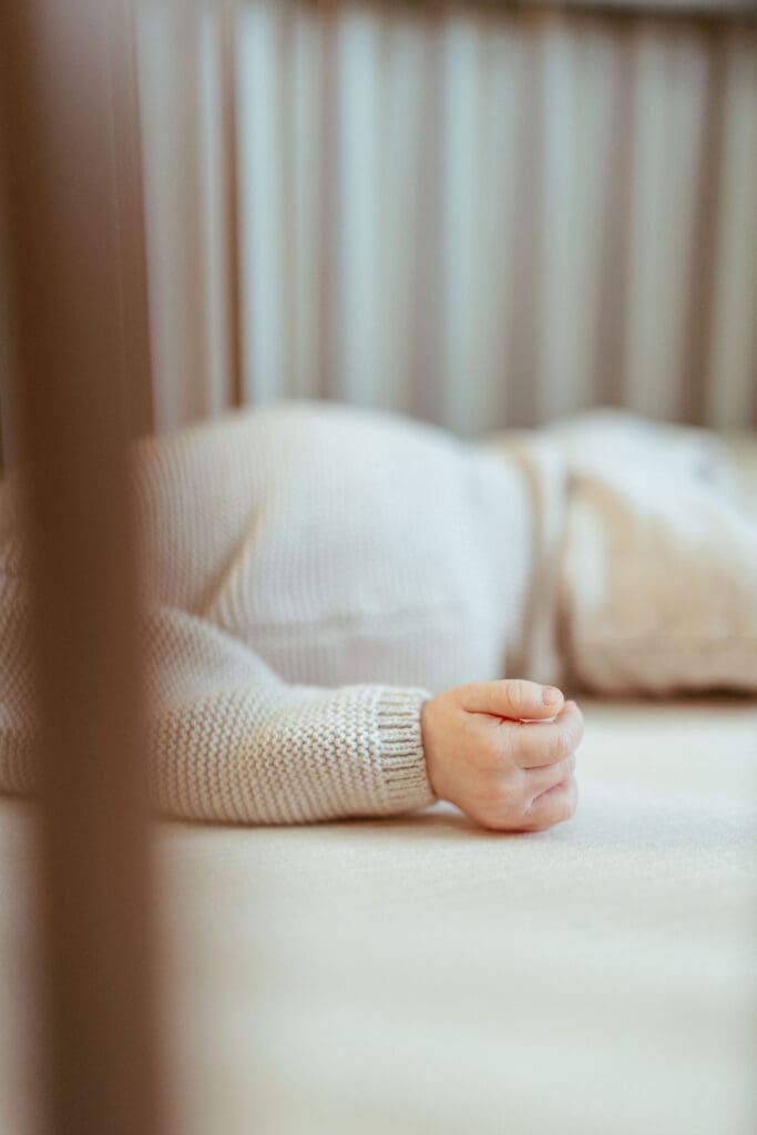 Natural in-home newborn photography session in Scottsdale Arizona featuring sleepy newborn baby in neutral knit outfit photographed by Scottsdale newborn photographer