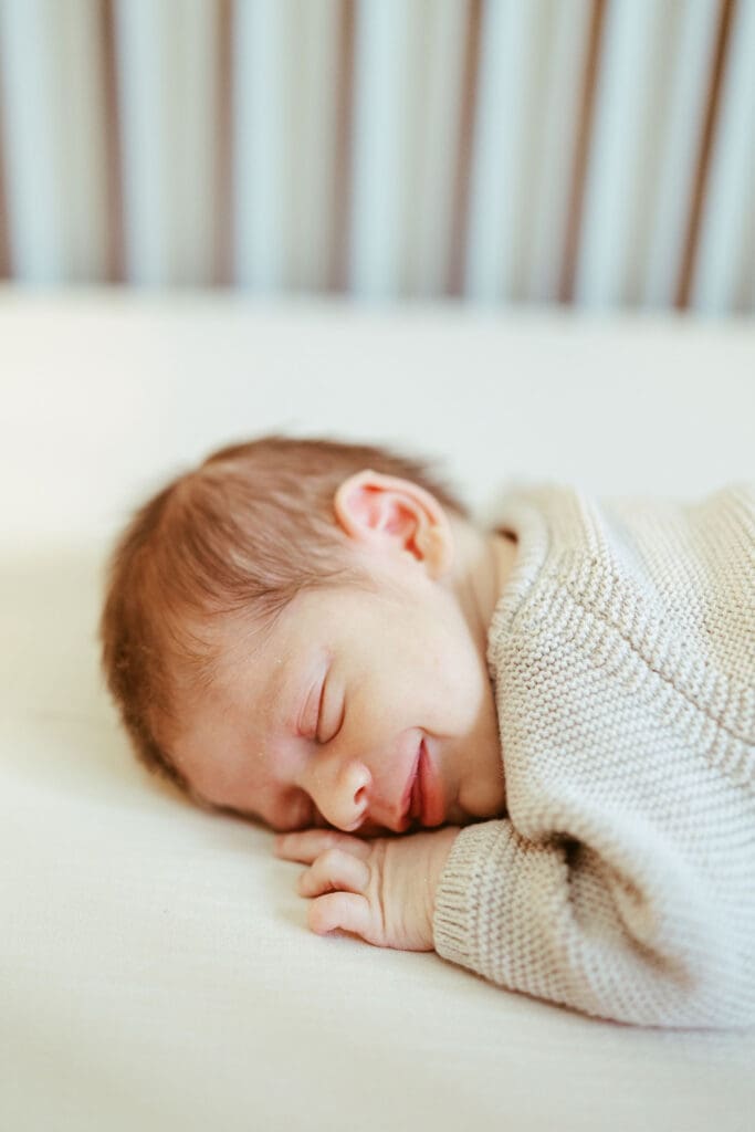 Scottsdale Arizona lifestyle newborn photographer holding sleepy newborn baby during in-home newborn photography session in Scottsdale AZ near Phoenix and Paradise Valley