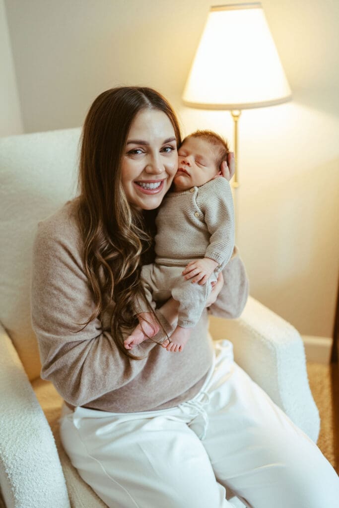 In-home newborn photography in Scottsdale Arizona capturing newborn baby sleeping peacefully in cream knit outfit during natural lifestyle newborn session