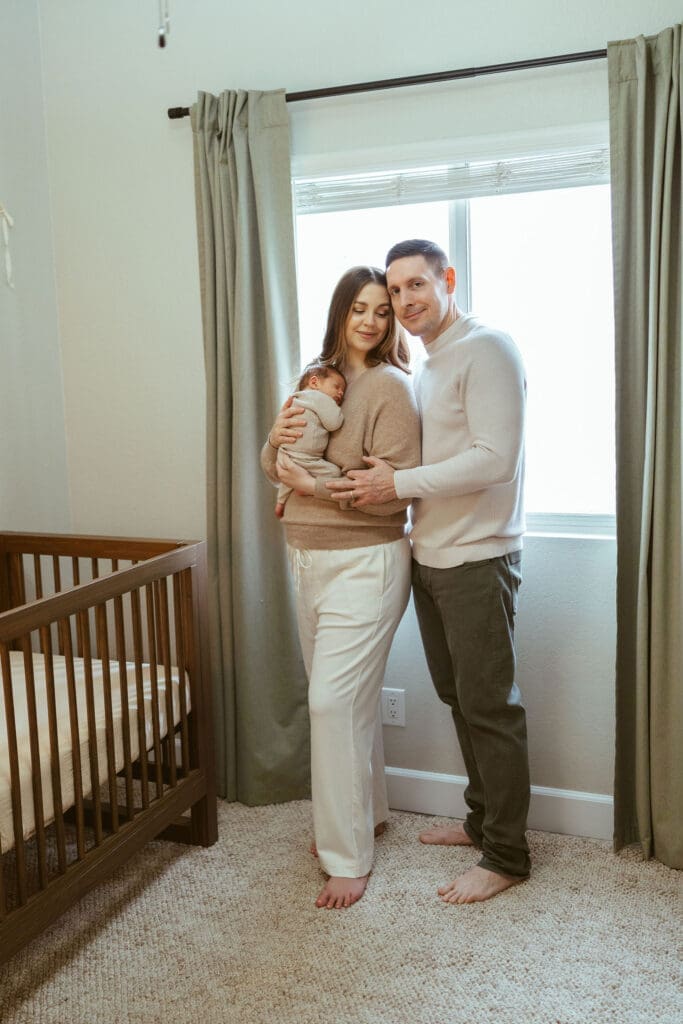 In-home newborn photography in Scottsdale Arizona capturing newborn baby sleeping peacefully in cream knit outfit during natural lifestyle newborn session