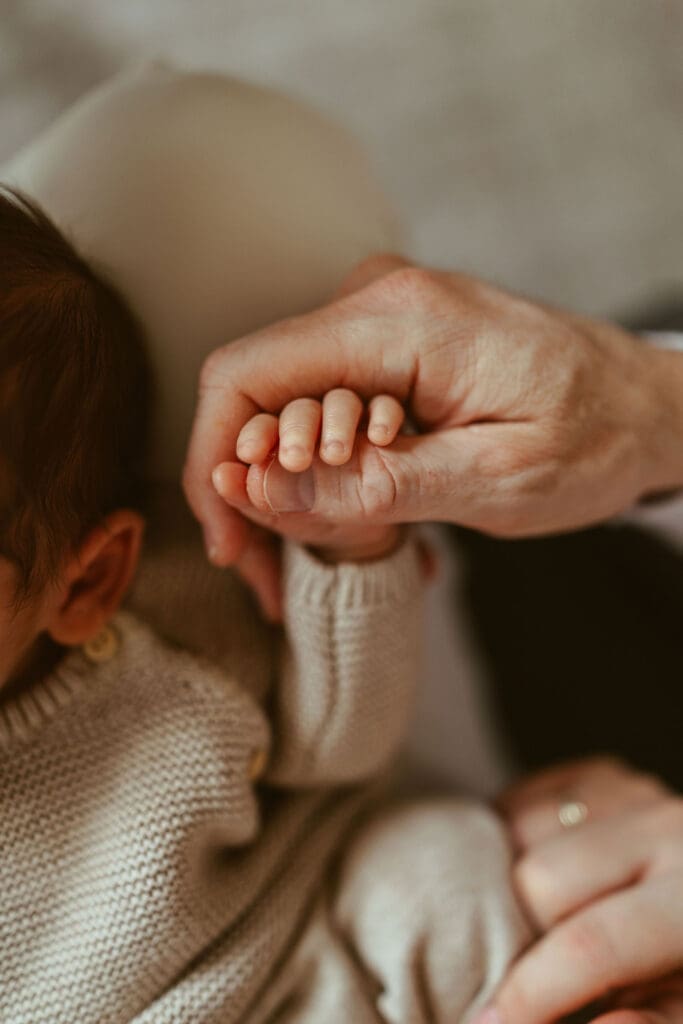 In-home newborn session in Scottsdale Arizona capturing tiny newborn details and emotional family connection with warm natural light photography