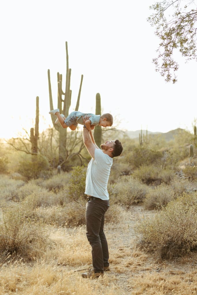 Arizona family photographer capturing playful father and son moments with saguaro cactus backdrop