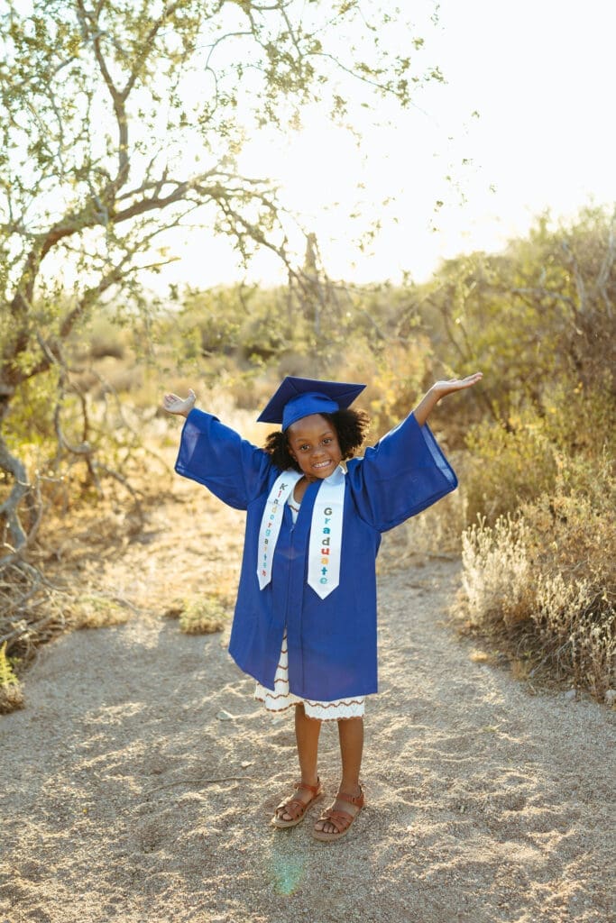 Kindergarten graduate wearing a blue cap and gown during a family photo session in Arizona