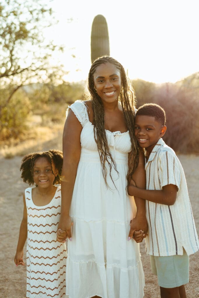 Mother and children smiling together beneath a saguaro cactus during a desert family session