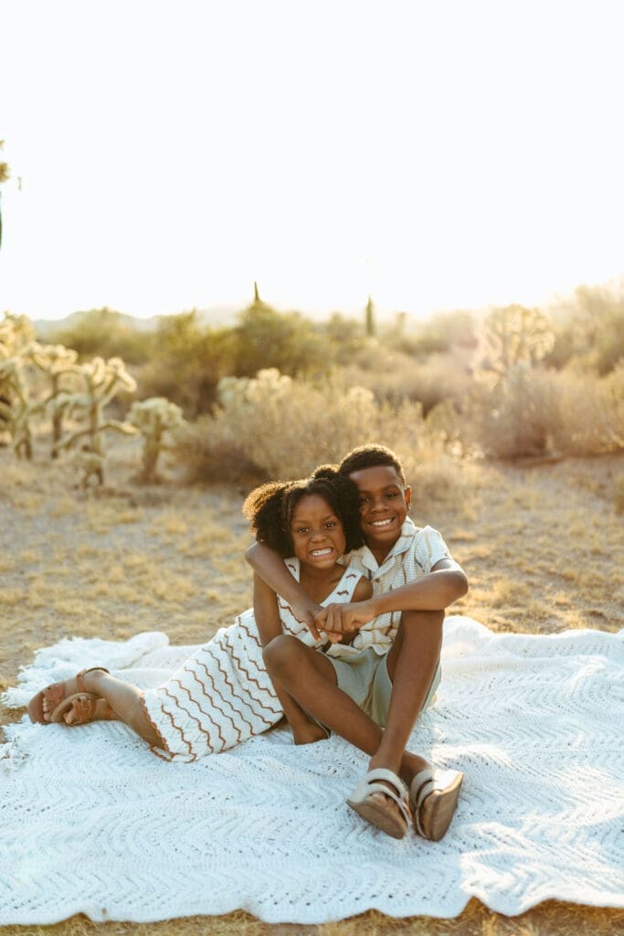 Playful family cuddling on a blanket during a golden hour family photo session near Scottsdale