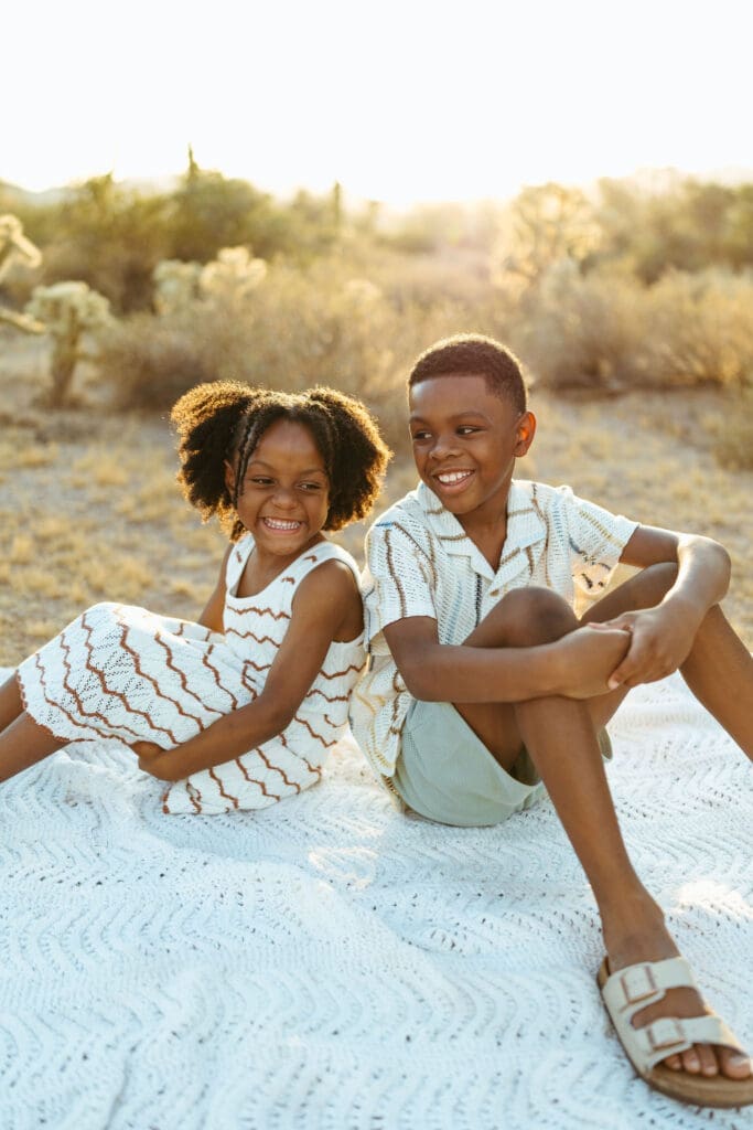 Playful family cuddling on a blanket during a golden hour family photo session near Scottsdale